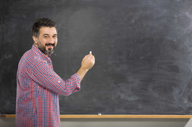 Teacher at blackboard modeling how to solve math word problems